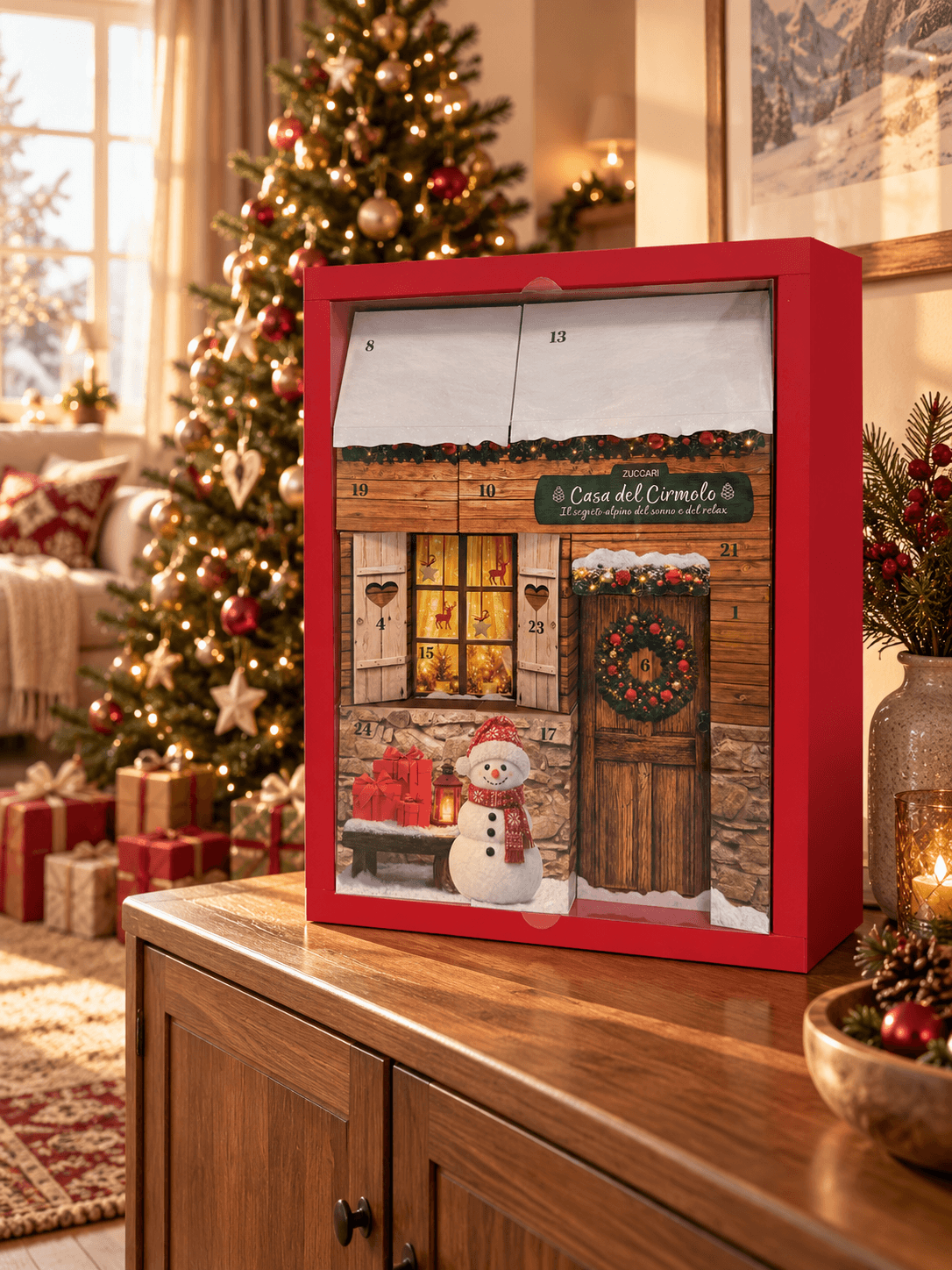 Il Calendario dell’Avvento Casa del Cirmolo su una credenza in legno, accanto a un albero di Natale illuminato